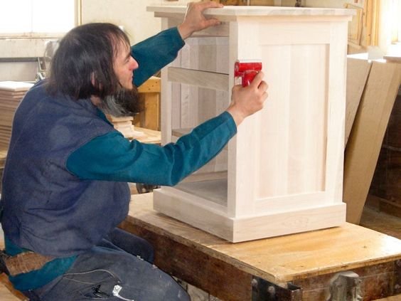 An Amish craftsman working on a cabinet